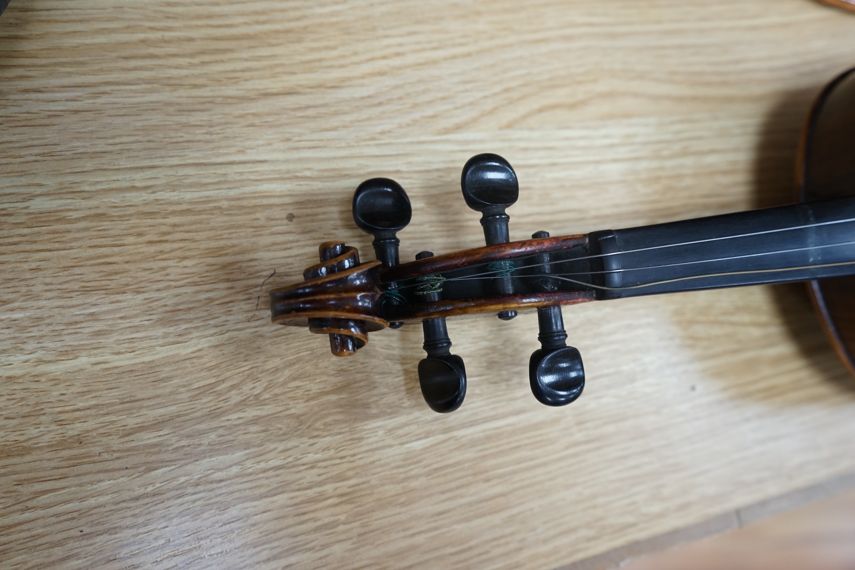 An early to mid 20th century violin, interior label reads ‘Copy of Antonius Straduarius made in Germany’, cased with bow, back measures 33.5cm. Condition - fair to good